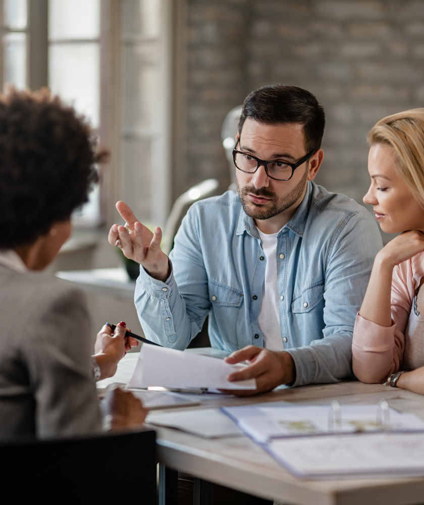 mid-adult-couple-discussing-with-financial-advisor-while-analyzing-documents-meeting-office