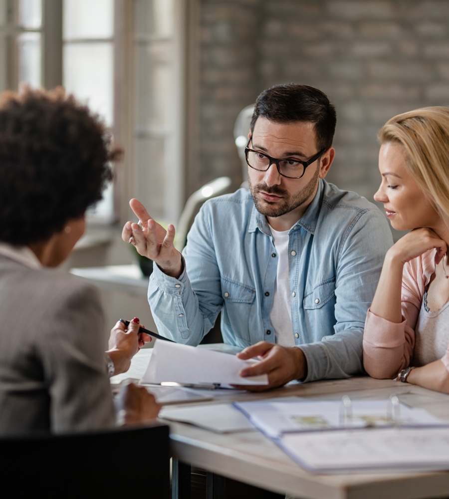 mid-adult-couple-discussing-with-financial-advisor-while-analyzing-documents-meeting-office